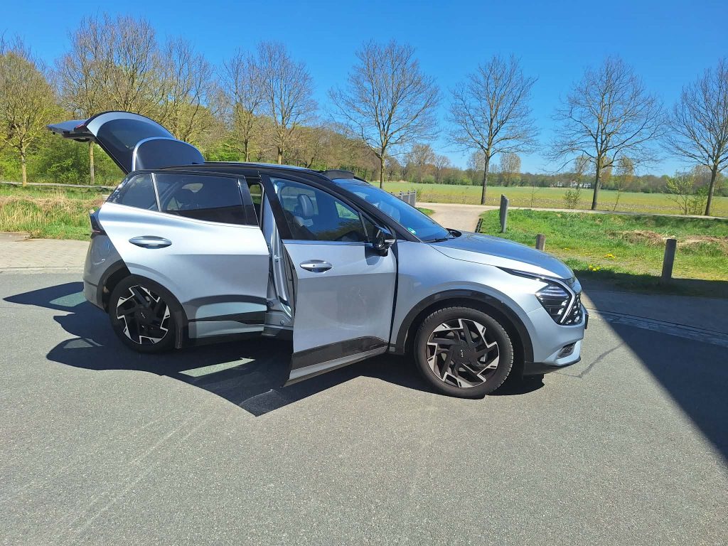 Kia Sportage Premium des Care Fahrdienst Bremen – Seitenansicht Tueren auf Feld