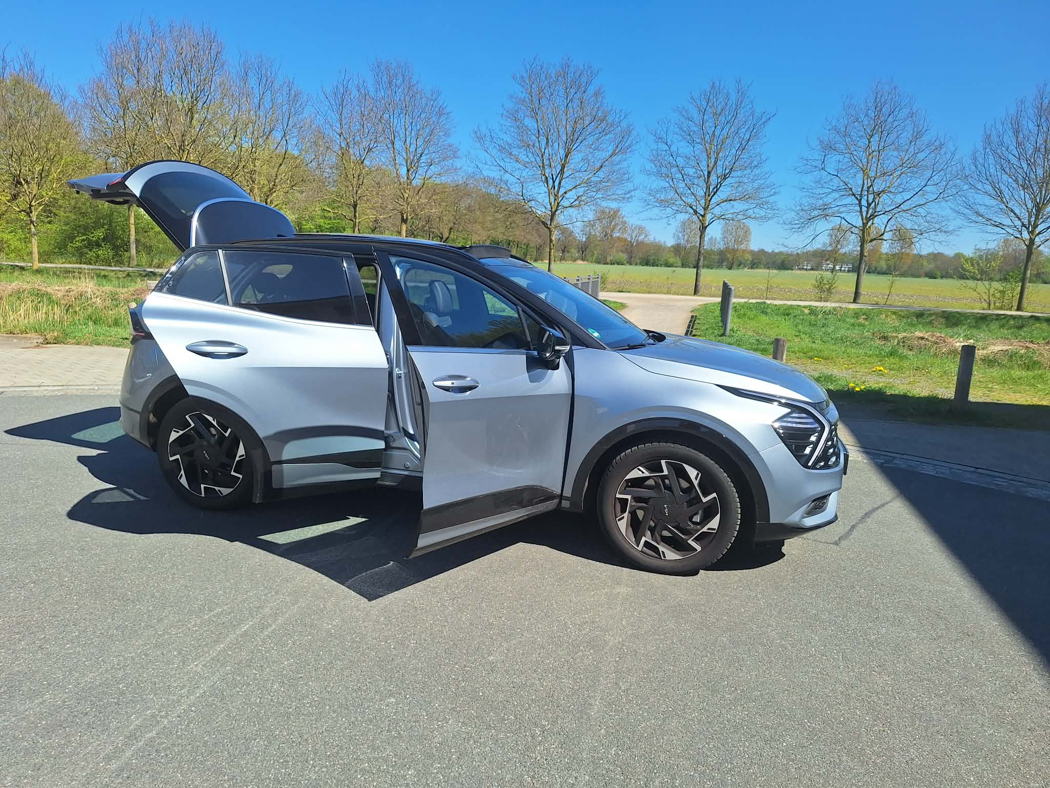 Kia Sportage Premium des Care Fahrdienst Bremen – Seitenansicht Tueren auf Feld