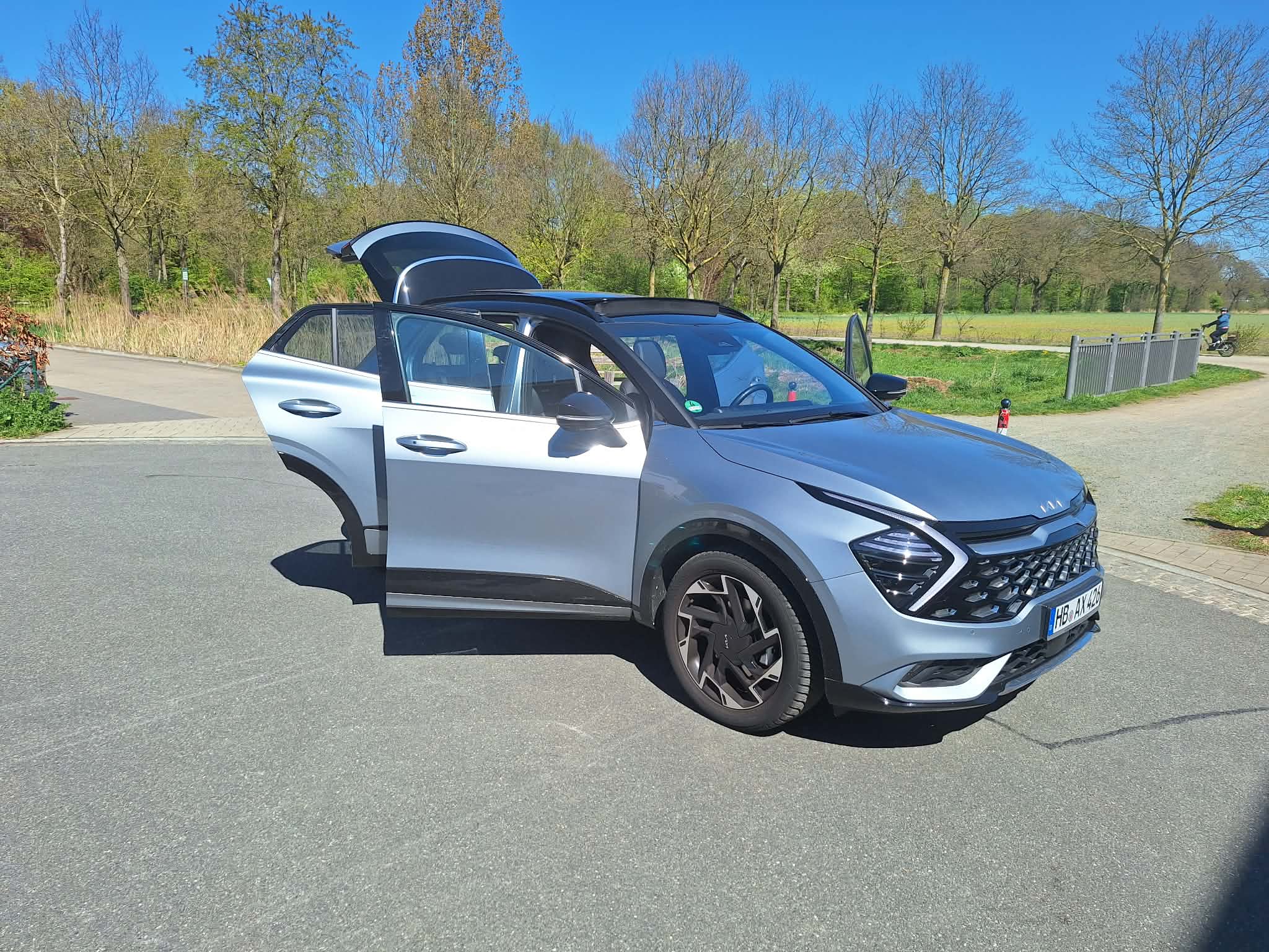 Kia Sportage Premium des Care Fahrdienst Bremen – Front/Seitenansicht Tueren auf Feld